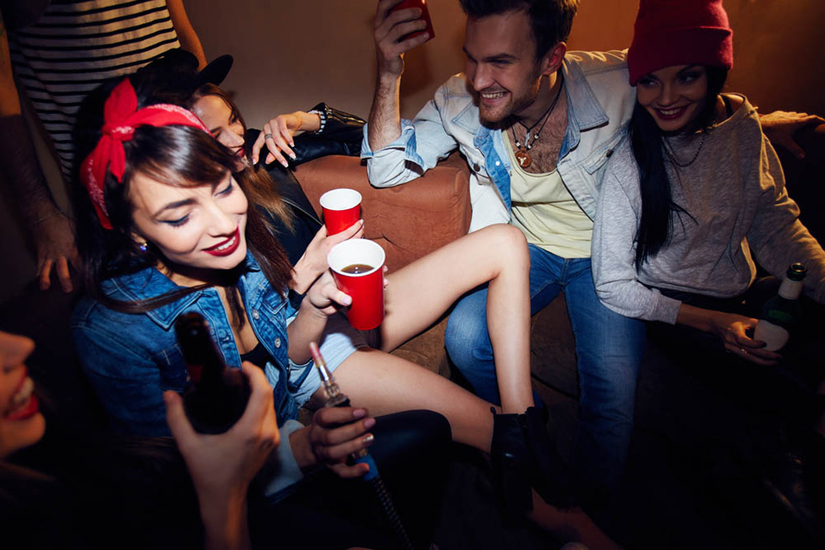 group of young people drinking alcohol in a club