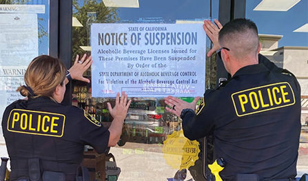 Police posting a suspension sign on a store’s window
