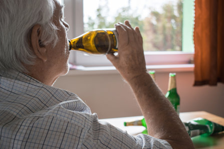 Elderly man drinks alcohol