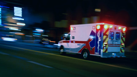 An ambulance rushes on a call at night. 