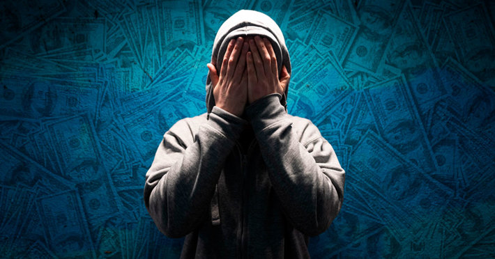 Addict covering face, money background