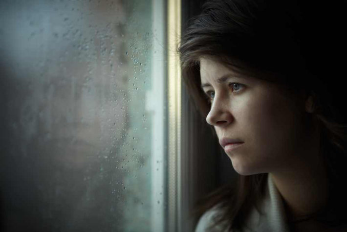sad woman looking out window