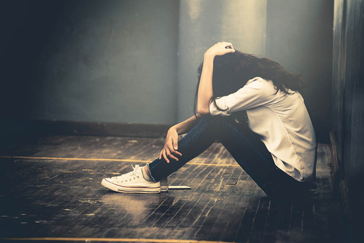 young depressed teen in dark hallway