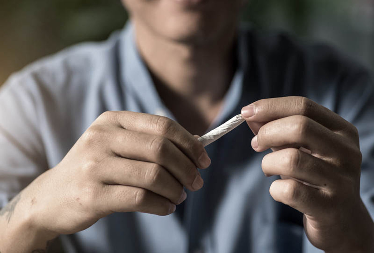 man holding a marijuana joint