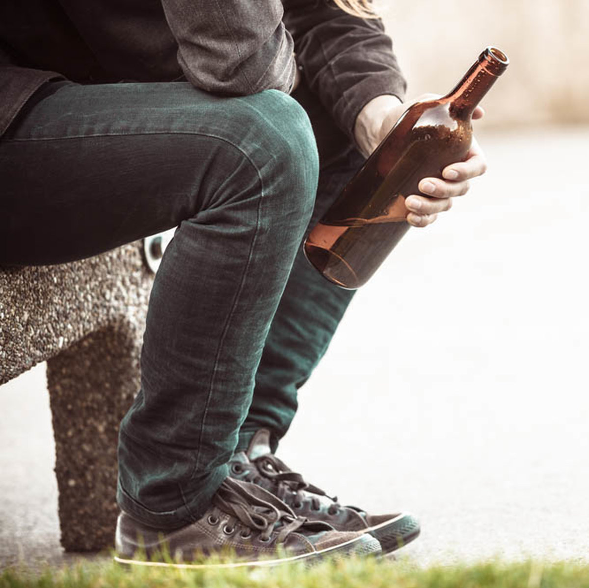 Man drinking alcohol on a bench