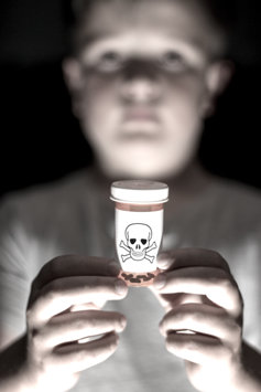 Kid holding deadly prescription drugs