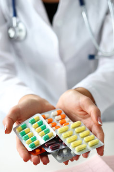 A doctor hands out pills.