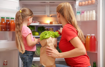 Mother teaching daughter to choose right healthy food.