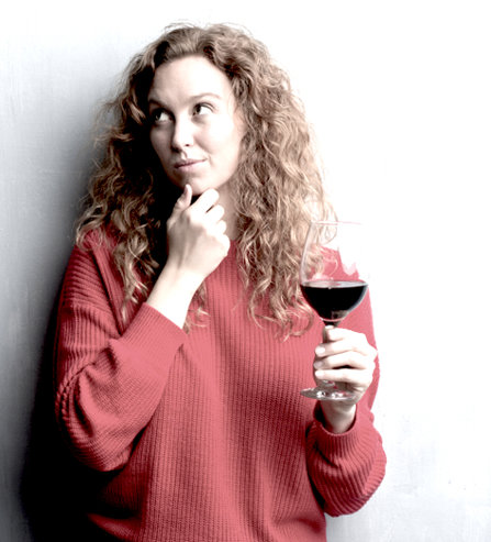 Woman with glass of wine, thinking.