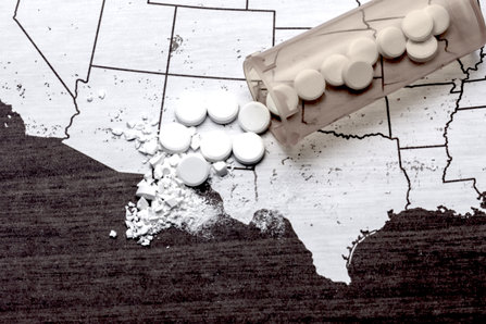 Opioid pills on American map.