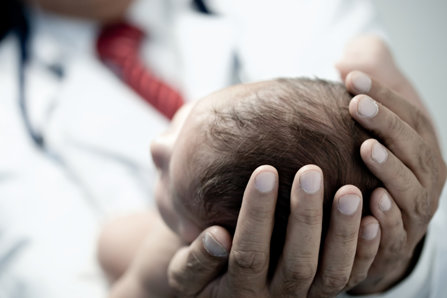 Doctor holds an infant