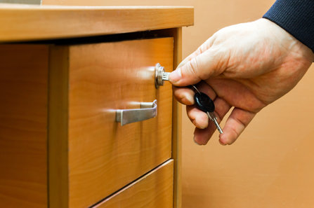 A person is locking the cabinet