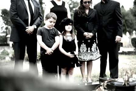 Children standing at the parents grave.