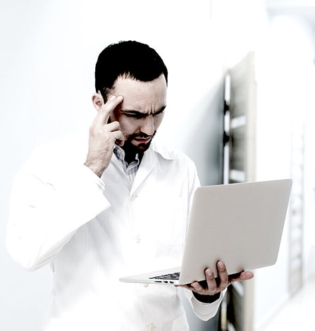Doctor looking at computer and deeply thinking.