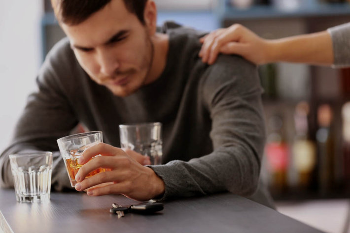 family member reaching to help an alcoholic