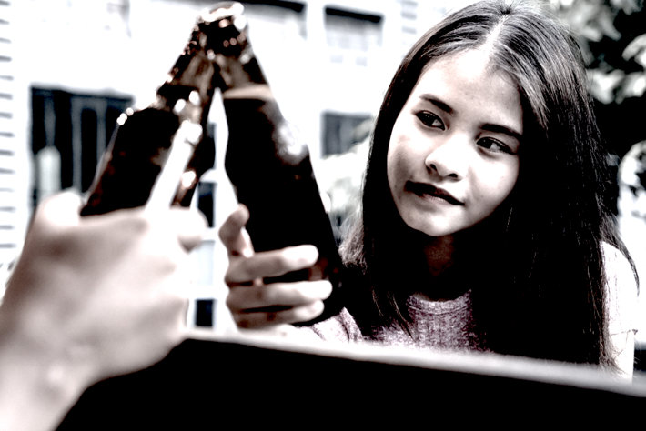 Little girl holding bottle of beer. 