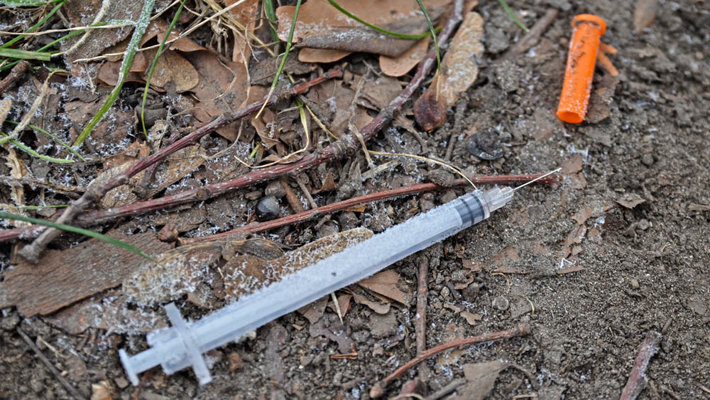 used syringe in a park