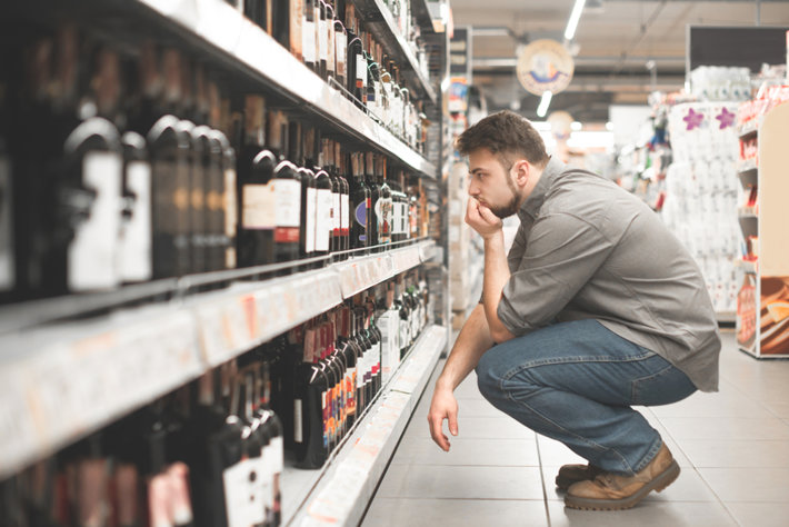 Man in alcohol section of grocery  store