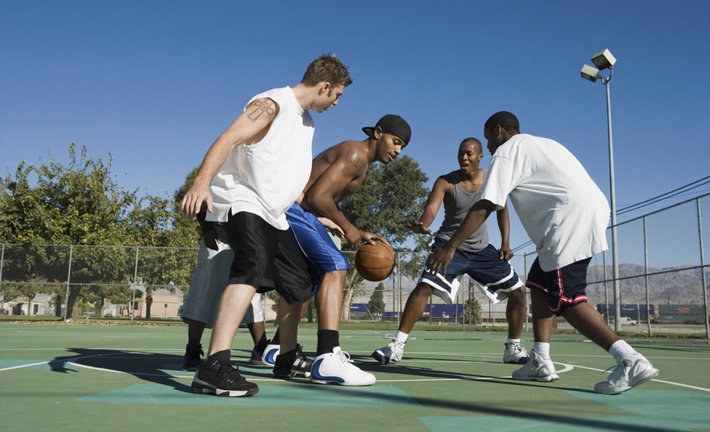 friends playing basketball at the park