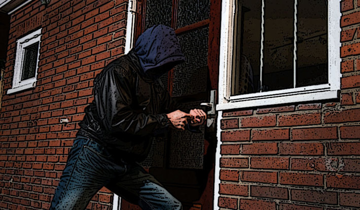 A man breaking into a house. 