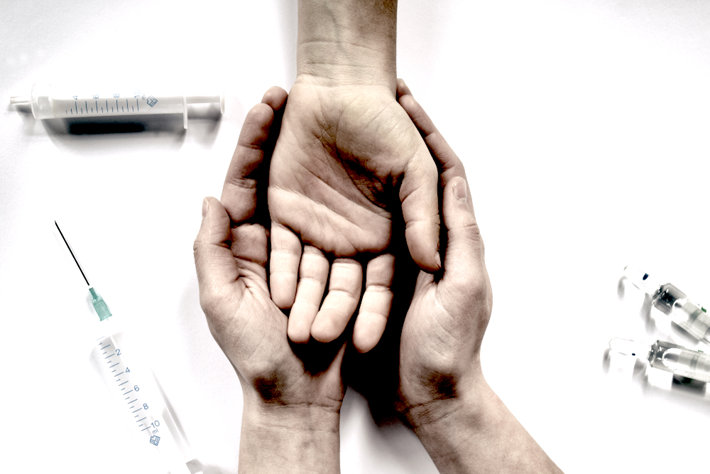 Hands holding teens hand—opioid overdose.