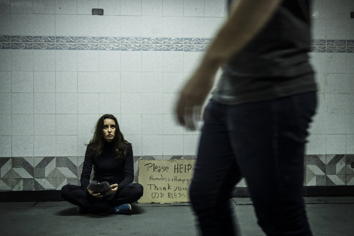 A homeless addict woman sits in a tunnel