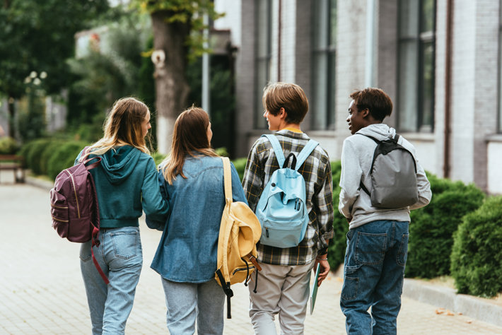 Teenagers walking by a school