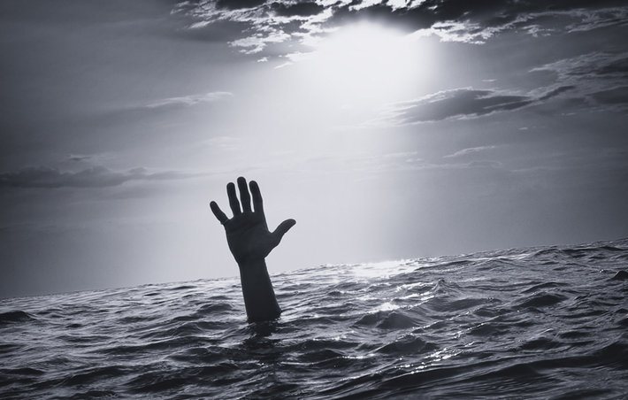 A hand emerging from the water, indicating that someone urgently needs help. 