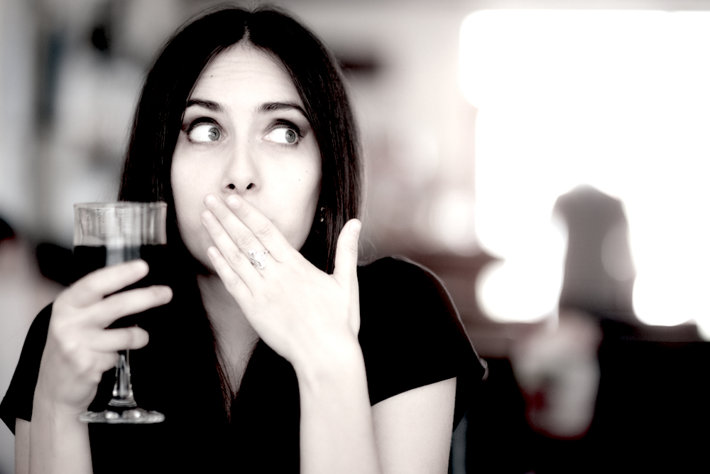 Surprised woman drinking alcohol